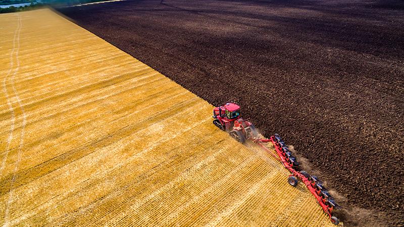 Farmer in tractor preparing farmland